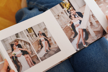 Female hands flipping through a photo book with wedding photosの写真素材