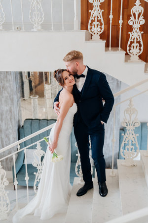 Beautiful and happy bride and groom on a large beautiful staircase.の写真素材