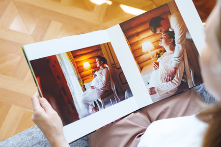 woman is holding and flipping through a photo book with a pregnancy photo shootの写真素材