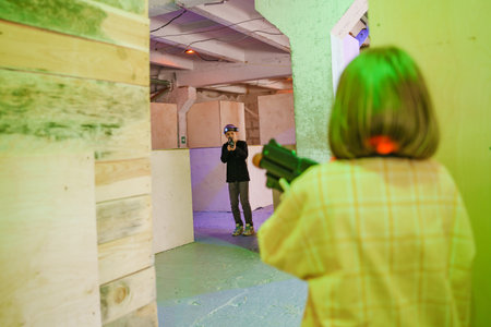Indoor laser tag game in a colorful arena at nightの写真素材