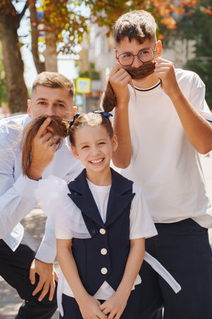 Playful kids and adults having fun with hair in a sunny outdoor settingの写真素材