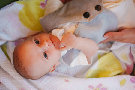 Baby dressed in formal attire laying on a colorful blanket