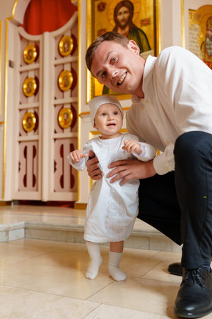 Happy father and baby in church during baptism ceremonyのeditorial素材