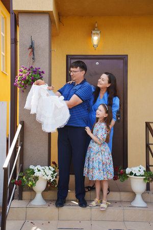 Family celebrates new arrival in front of their home