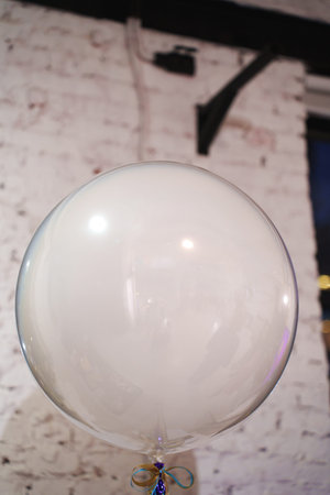 White balloon floating above the floor at a gathering in a room