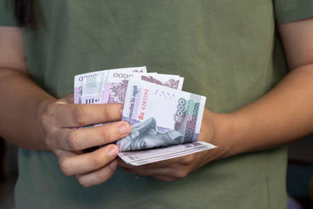 Cambodian female sale vendor hand counting moneyの写真素材