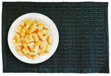 Food of cantaloup cut on black reed mat