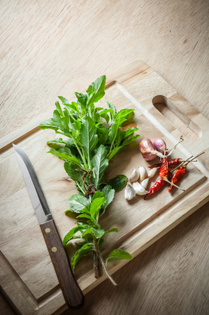 Spices and holy basil herbs on wood chopping blockの写真素材