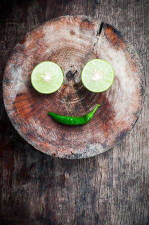 Green Lemon cut and chilli on wood blockの写真素材