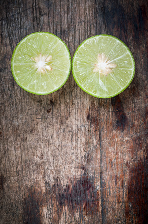 Green Lemon cut on wooden backgroundの写真素材