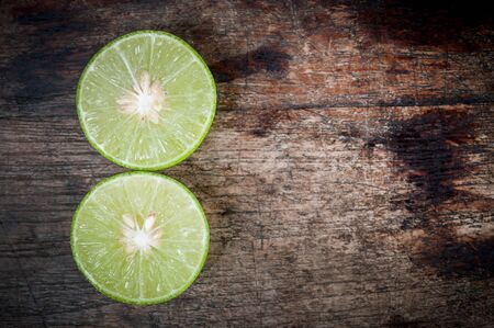 Green Lemon cut on wooden backgroundの写真素材