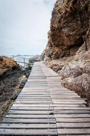 Wooden pathway with rock valley or cliff on the islandの写真素材