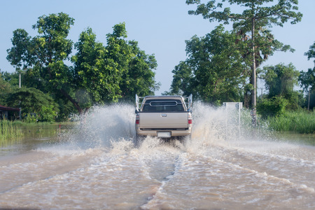 Car running on the road with water floodの写真素材