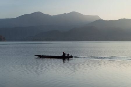 engine boat running on the lake with mountain background closeupの写真素材