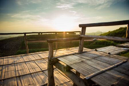 Closeup of bamboo chair with sunrise landscapeの写真素材