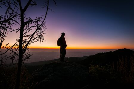 Silhouette light person looking sunset landscapeの写真素材