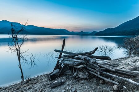 stack of log with lake and mountain landscapeの写真素材