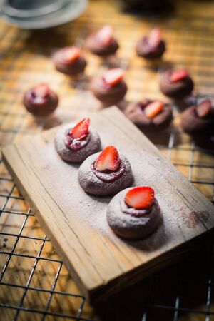 Chocolate cookie with strawberry fruit on chopping blockの写真素材
