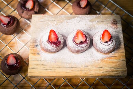 Chocolate cookie with strawberry fruit on chopping blockの写真素材