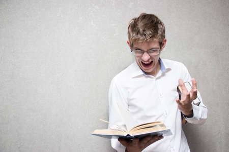 A young man with glasses and a white shirt with books in his hands