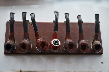 seven pipes on a pipes' stand on the table