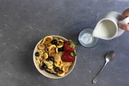 pancake porridge with milk, tiny pancakes with strawberries and blueberries, the concept of a home breakfast in the quarantine period, flat layの写真素材