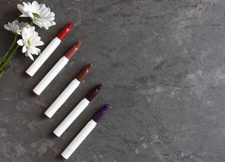 diagonal set of lipsticks, gray concrete background, flat lay, mock up for inscriptionsの写真素材