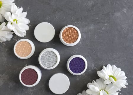 set of decorative cosmetics, eye shadow, branding mockup, flat lay, cosmetics and white flowers on gray background
の写真素材