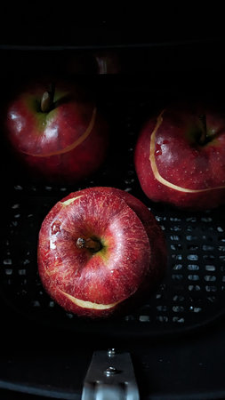 Red Apples Ready for Baking. Fresh red apples placed on a surface, washed and ready for baking or cooking, showing their vibrant color and smooth texture.の写真素材