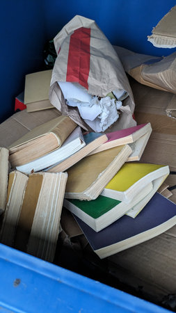 Discarded Books and Paper Waste in a Recycling Binの写真素材