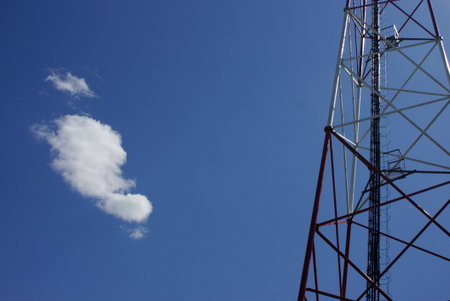 Communication Tower Against Blue Sky with White Cloudの写真素材