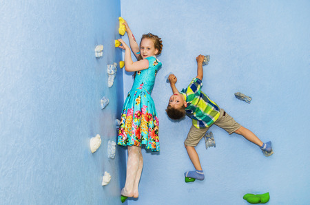 boy and girl playing in a children's climbing wallの写真素材
