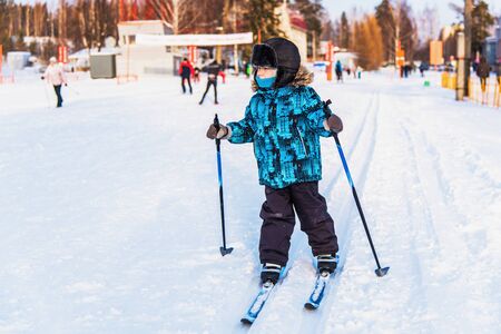boy goes skiing on the starting field at the ski stadium in winter sunny dayの写真素材