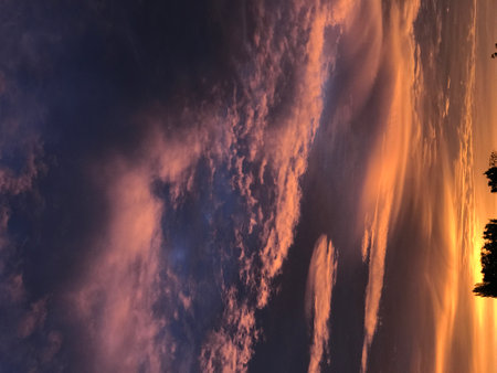 Sunset sky with clouds and sunbeams. Nature background.の写真素材