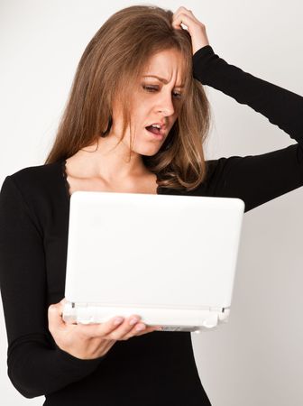 portrait of young business woman with white laptop on grayの写真素材
