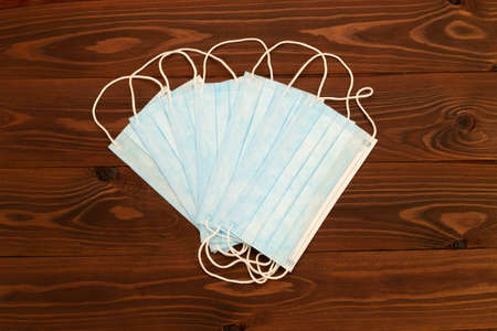 Blue surgical 3-ply disposable protective medical face masks with rubber ear straps to cover the...