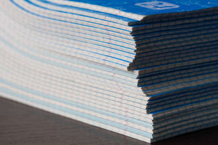 Stack of Notebooks. A pack of blue school notebooks on the brown table in a classroom. Stack of...