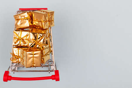 Black Friday concept. Shopping cart on the table. Metal shopping cart with wheels on a white background. Ready to shopping. Online discount ads. Copy space for text. Top view. Isolated. Close-upの写真素材