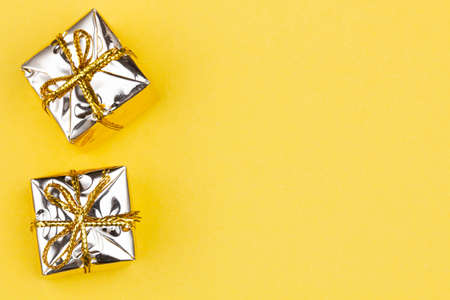 Box with gift on a yellow background with copy space for text. Golden boxes with gifts. Christmas gift boxes. Holidays Gifting. New Year gift boxes to family woman, man. Top view. Close-upの写真素材