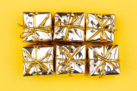 Box with gift on a yellow background. Golden boxes with gifts. Christmas gift boxes. Holidays...