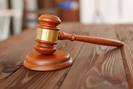 Judge hammer against the background of the courtroom. Judge gavel. Small ceremonial mallet made of hardwood. Court hammer. Judge mallet is a symbol of the authority. Justice symbol. Low conceptの写真素材