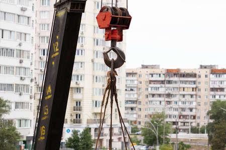 Crane hook. Tower Crane Hoist Rope against the blue sky and new building. Hawser of winch. Crane lifting cables. Construction site. Construction equipment. Close-Upの写真素材