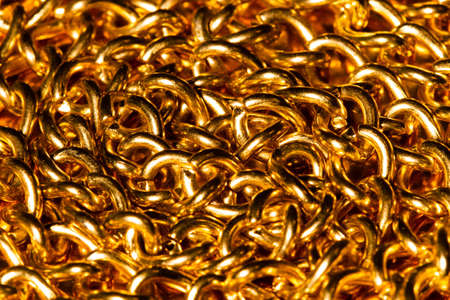 Golden chain. Detail of a yellow iron chain. Metal chain link on the gold background. Decorative jewelry. Luxury design brilliant jewelry. Beauty Gold necklace. Macro photo for ads, flyers. Ð¡lose-upの写真素材