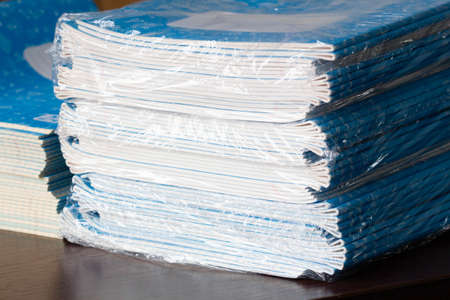 Stack of Notebooks. Back to school. A pack of blue school notebooks on the table in a classroom....
