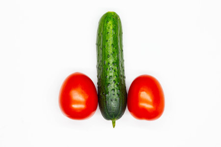 Male penis. Visual concept image of a male reproductive organ made from cucumber and tomato vegetables. Human anatomy. Male sexual organ. Big dick. Isolated. Close-upの写真素材