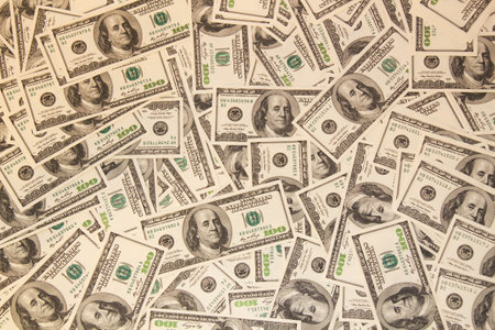 Many hundred dollar bills on the table. One hundred US dollar bills background. U.S. dollars. Banking and finance signs. Much money background. Top view. Close-upの写真素材