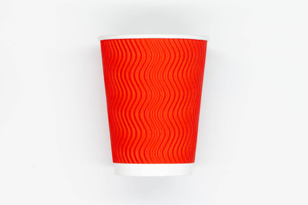 Paper coffee cup. Red craft paper coffee cup with yellow plastic lid. Disposable cup for safe drinking of hot and cold drinks. Safe ribbed capacity. Container for healthy beverage.の写真素材