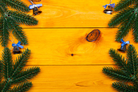 Christmas background. Fir and bells on the wooden table. New Year background. Christmas images, backgrounds. Xmas pine fir lush tree. Bright Winter holiday composition. Greeting caの写真素材
