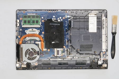 Disassembled laptop on a white background. Isolated. Broken dusty computer in a service workshop for...