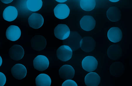 Soft colorful bokeh background. Luminous garlands of electric lights. Copy space to add text. Saturated colors. Blurry abstraction. Gentle tone. Dark night. Festive party in city. Defocus effect.の写真素材